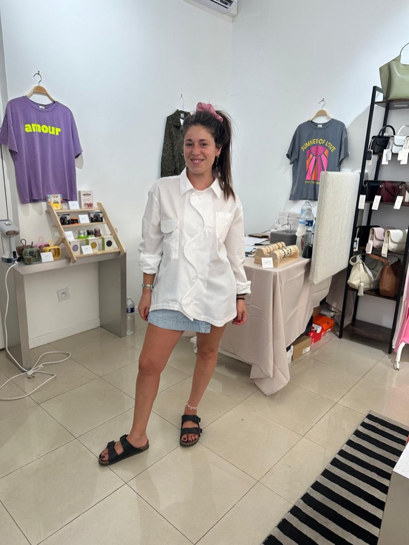 La Chemise Blanche portée avec une jupe-short en jean, patte de boutonnage ondulée