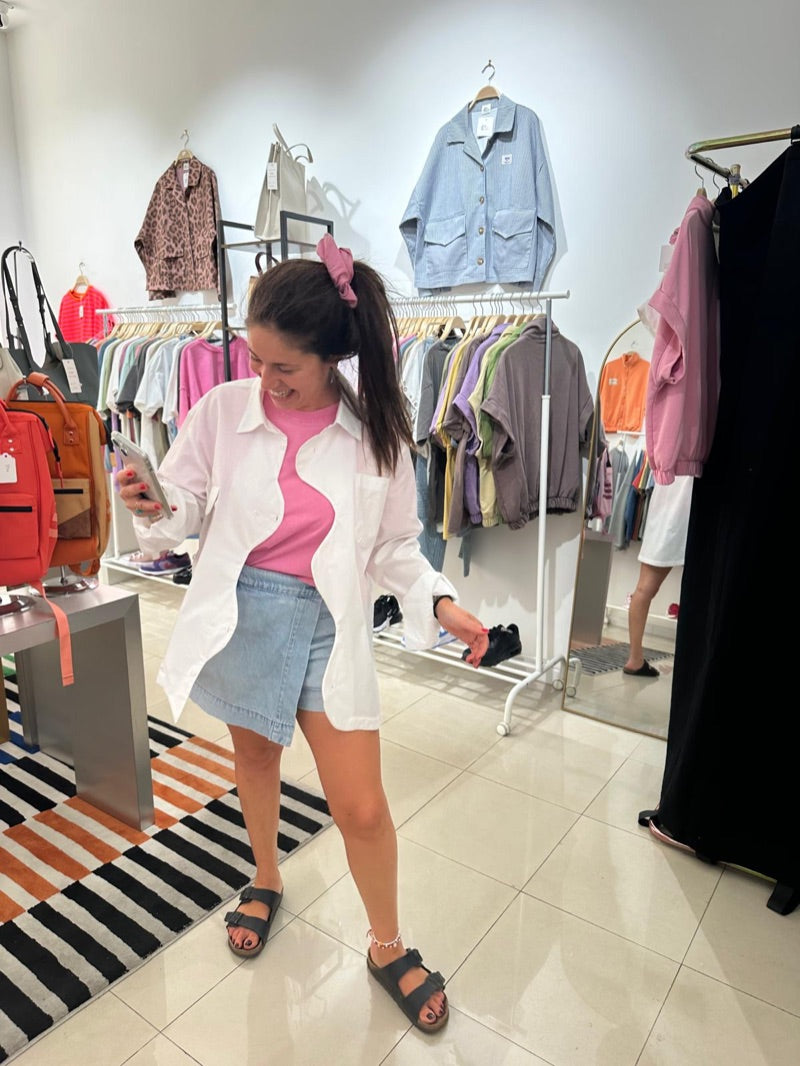 La Chemise Blanche portée ouverte sur un t-shirt rose